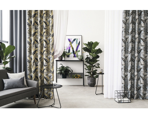 Woonkamer met bank, tafel en gordijnen met print