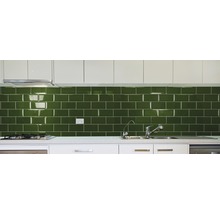 Keukenopstelling met groene metro tegels, spoelbak en kraan.