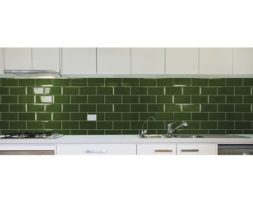 Keukenopstelling met groene metro tegels, spoelbak en kraan.