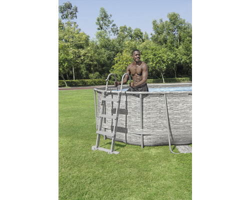 Opzetzwembad met ladder en persoon die in de tuin staat