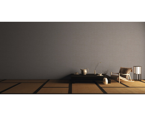 Woonkamer met textielbehang, fauteuil, tafel en tatamivloer voor een ontspannen sfeer