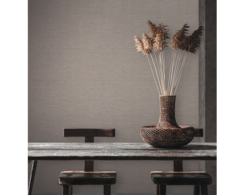 Scène met wandbekleding, houten tafel, stoelen en decoratieve vaas met planten.