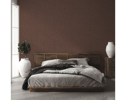 Slaapkamer met bruin patroonbehang, bed, nachtkastje en kamerplant