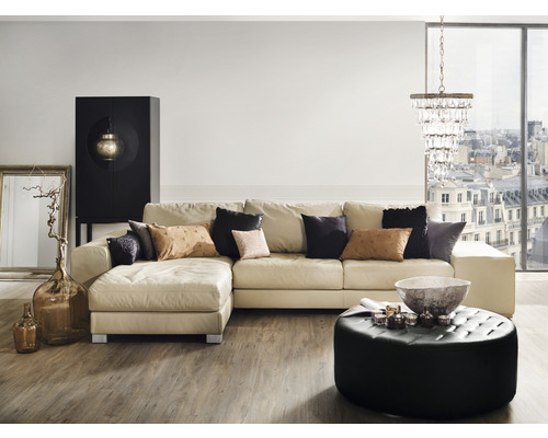 Woonkamer met hoekbank, salontafel, kast, vloerlamp en decoratie