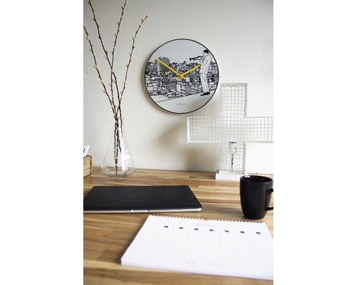 Decoratief bureau met wandklok, laptop, kop en kalender.