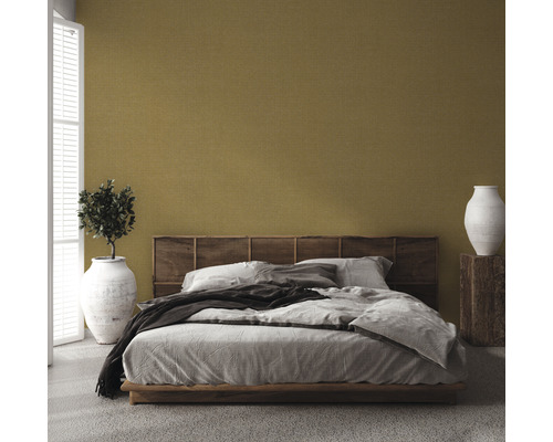 Slaapkamer met bed, houten hoofdeinde, plant in vaas en decoratieve vaas