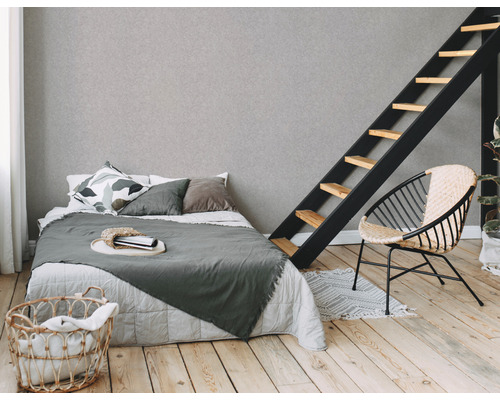 Lichte slaapkamer met bed, ladder, mand en stoel op houten vloer