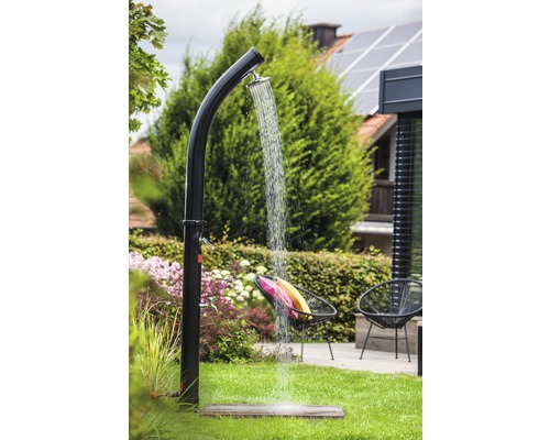 Tuinscene met buitendouche, gazon en tuinmeubilair