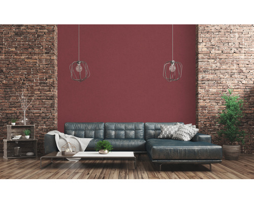 Woonkamer met leren bank, salontafel, decoratie en bakstenen muur