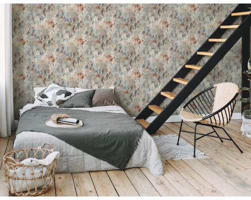 Een slaapkamer met een bed, een stoel en een trap voor een wand met een vlekpatroon.