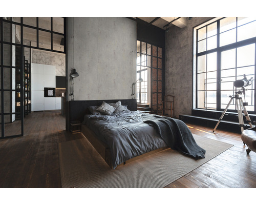 Loft-stijl slaapkamer met bed, vloerkleed en grote ramen