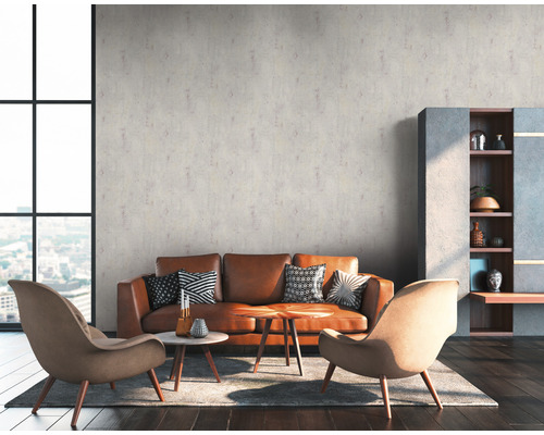 Woonkamer met bruine lederen bank, fauteuils en decoratie op houten vloer