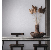 Scene met tafel, stoelen, vaas en decoratie tegen een lichte wand.