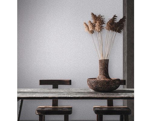 Scene met tafel, stoelen, vaas en decoratie tegen een lichte wand.