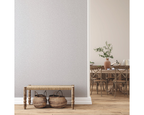 Lichte ruimte met behang, bank en eethoek op de achtergrond