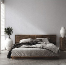 Slaapkamer met bed, houten hoofdeinde, plant en vaas