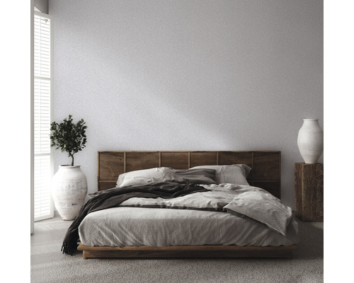 Slaapkamer met bed, houten hoofdeinde, plant en vaas