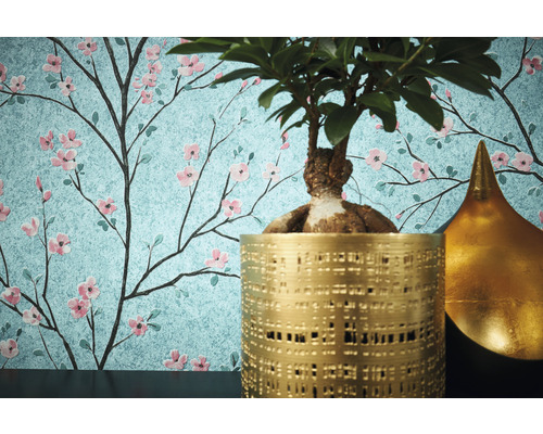 Decoratief behang met een bloemmotief van kersenbloesems, gecombineerd met een potplant en een goudkleurige decoratie.