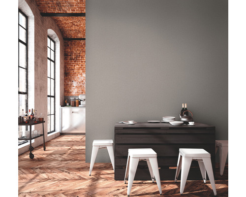 Lichte kamer met bakstenen muur, parketvloer, serveerwagen en eethoek