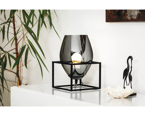 Decoratieve tafellamp met een lichtbron in een zwart metalen frame