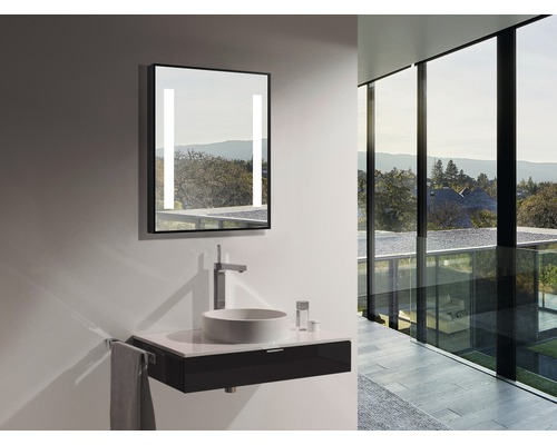 Moderne badkamer met verlichte spiegel, opzetwastafel en wastafelonderkast.