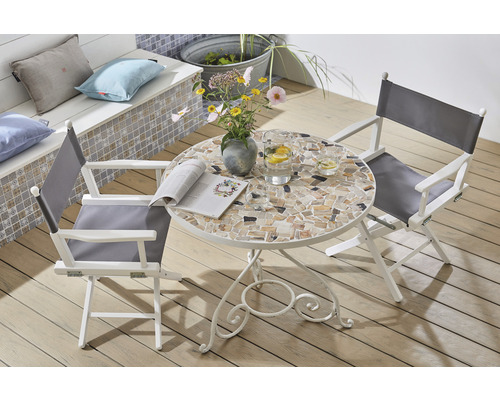 Tuinscene met mozaïektafel, regisseursstoelen, bloemen en drankjes buiten