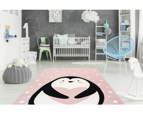 Kinderkamer met roze vloerkleed met pinguïnpatroon, ledikant en speelgoed