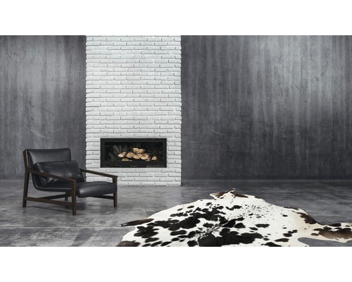 Woonkamer met fauteuil, open haard en vloerkleed in koeienhuid design