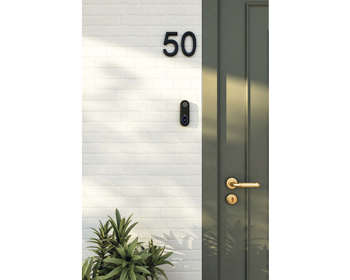 Buitenmuur met huisnummer, deurbel en voordeur