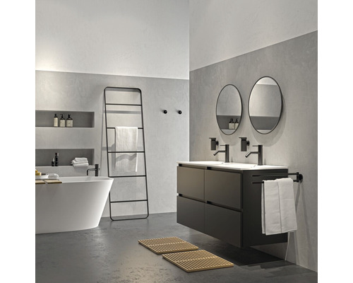 Badkamer met bad, wastafel, spiegels en handdoekladder in modern design.