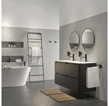 Badkamer met ligbad, wastafel, spiegels en handdoekladder