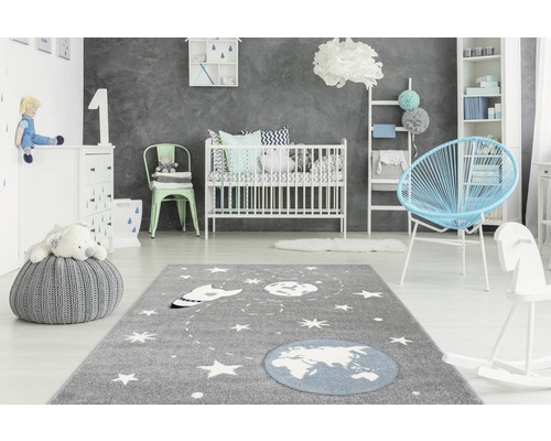 Kinderkamer met tapijt, babybed, fauteuil en speelgoed
