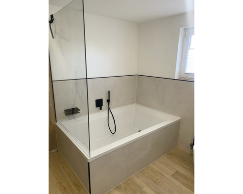 Badkamer met ligbad, douchewand en tegels