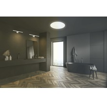 Moderne badkamer met bad, wastafel, spiegel, wandlampen en plafondlamp