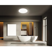 Badkamer met bad, wastafel, spiegel en plafondlamp