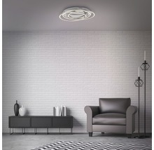 Woonkamer met plafondlamp, fauteuil en dressoir