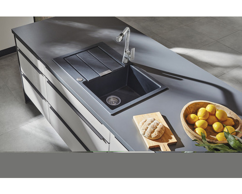 Keuken spoelbak met afdruiprek, kraan, snijplank en citroenen