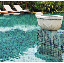 Close-up van een zwembad met mozaïektegels en decoratieve plantenbak