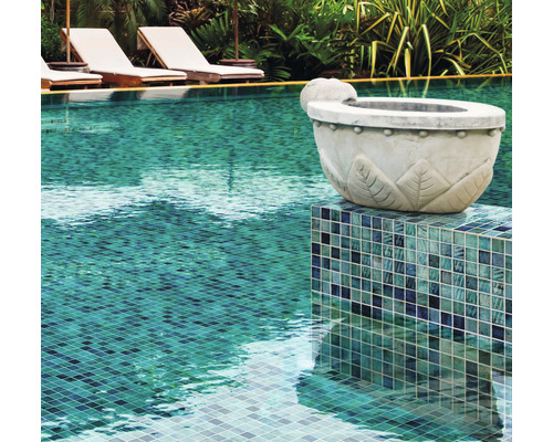 Close-up van een zwembad met mozaïektegels en decoratieve plantenbak