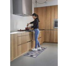 Vrouw kookt in een lichte keuken met een keukenloper