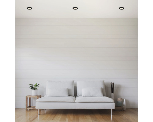 Woonkamer met plafondlampen, bank en decoratie