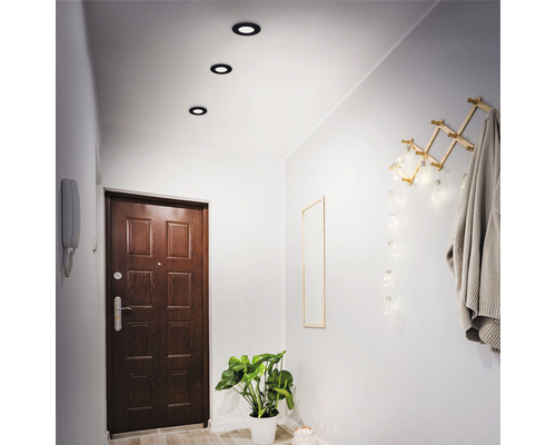 Hal met plafondlampen, deur, spiegel en kapstok
