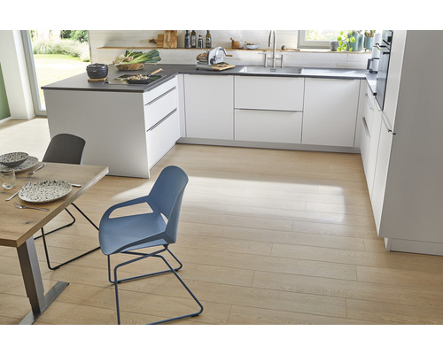 Lichte en ruime keuken met witte kasten, donkere werkbladen, houten vloeren, eettafel en stoelen