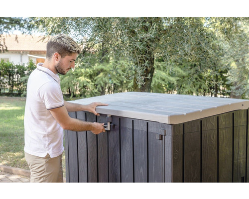 Man opent een tuinkist met deksel buitenshuis