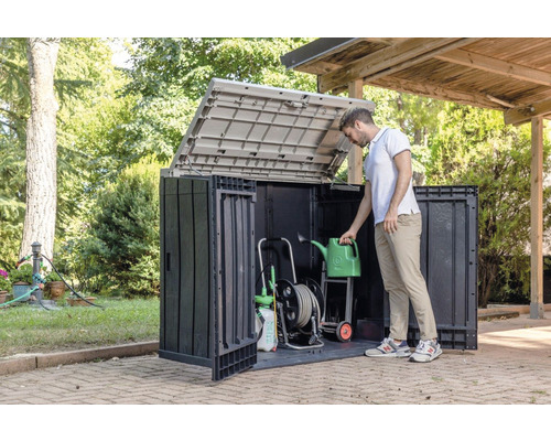 Tuinkast met open deksel en tuingereedschap, plus een persoon die een gieter vasthoudt