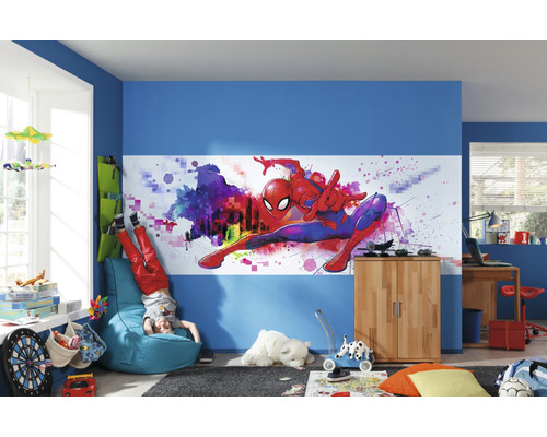 Gedecoreerde kinderkamer met Spider-Man muurschildering, blauwe muren en diverse meubels.