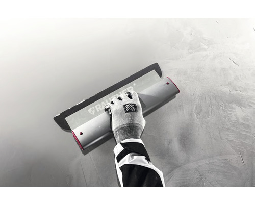 Ambachtsman gebruikt een pleisterspaan om een muur te bepleisteren