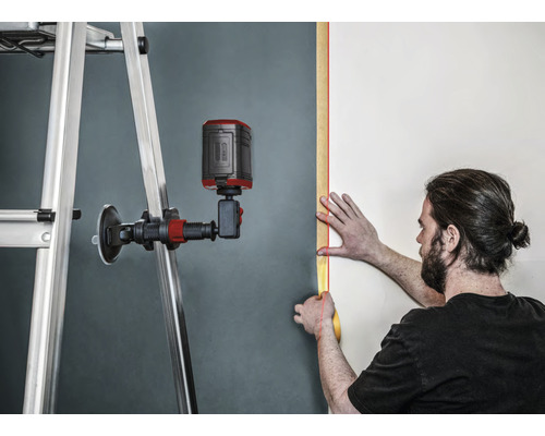Gebruiker met lijnlaser bij het uitlijnen op een muur met ladder