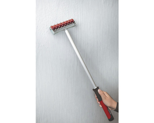 Behang aandrukrol met steel en hand op een muur