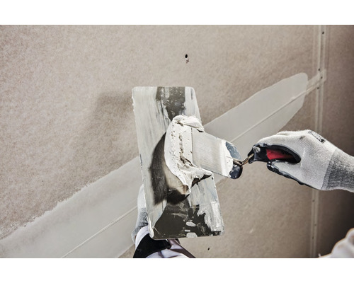 Vakman maakt pleister glad met een plamuurmes